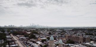 Aerial view showcasing Philadelphia's skyline and urban landscape with a historic church in the foreground.