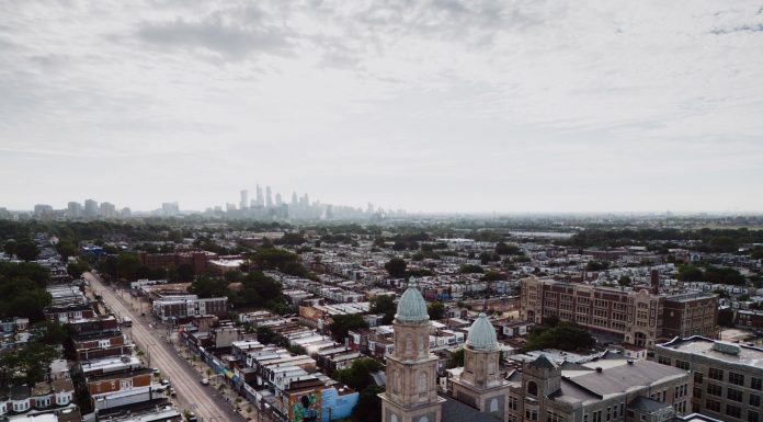 Aerial view showcasing Philadelphia's skyline and urban landscape with a historic church in the foreground.