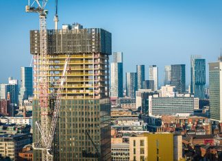 Aerial view of modern skyscrapers in Manchester with ongoing construction highlighting urban growth.
