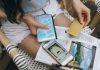 A woman uses her smartphone and credit card for online shopping while sitting outdoors.
