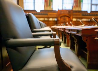 Elegant courtroom seating with leather chairs and wooden desks, exuding a sense of authority.