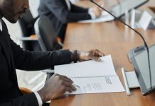 Jersey City Councilman Hosts Budget Town Hall Amid $255 Million Deficit Professional businessman examining budget documents during an office meeting, showcasing focus and analysis.