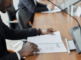 Jersey City Councilman Hosts Budget Town Hall Amid $255 Million Deficit Professional businessman examining budget documents during an office meeting, showcasing focus and analysis.