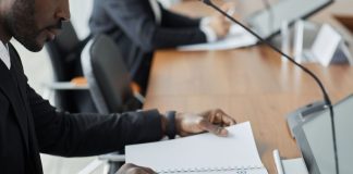 Jersey City Councilman Hosts Budget Town Hall Amid $255 Million Deficit Professional businessman examining budget documents during an office meeting, showcasing focus and analysis.