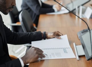 Professional businessman examining budget documents during an office meeting, showcasing focus and analysis.