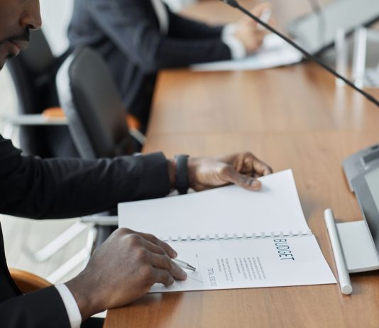 Professional businessman examining budget documents during an office meeting, showcasing focus and analysis.