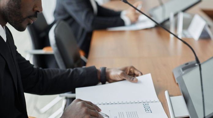 Professional businessman examining budget documents during an office meeting, showcasing focus and analysis.