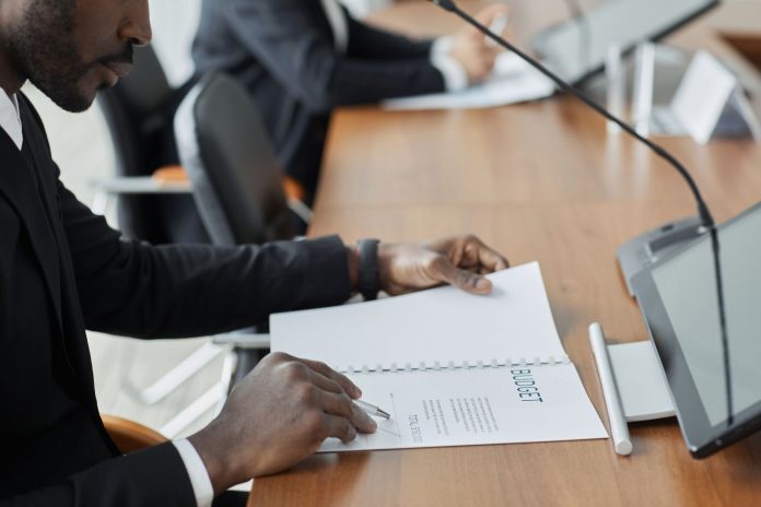 jersey-city-councilman-hosts-budget-town-hall-amid Professional businessman examining budget documents during an office meeting, showcasing focus and analysis.