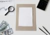 Flat lay of financial tools and blank paper for planning or mockup.