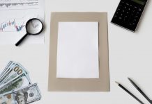 Flat lay of financial tools and blank paper for planning or mockup.