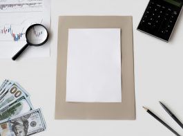 Flat lay of financial tools and blank paper for planning or mockup.