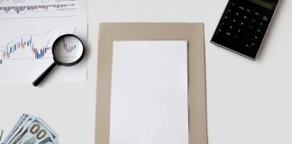 Flat lay of financial tools and blank paper for planning or mockup.