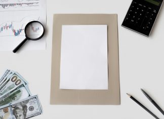 Flat lay of financial tools and blank paper for planning or mockup.