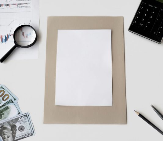Flat lay of financial tools and blank paper for planning or mockup.