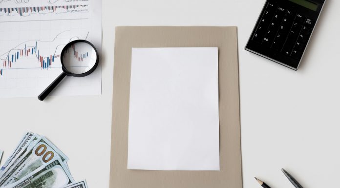 Flat lay of financial tools and blank paper for planning or mockup.