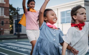 Jersey City Families Find Summer Fun Close to Home Three kids enjoying superhero play on a sunny outdoor court.