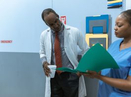 Doctors and nurse discussing medical charts in hospital setting.