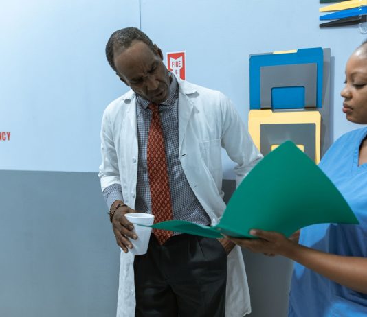 Doctors and nurse discussing medical charts in hospital setting.