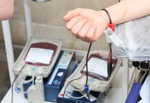 Jersey City Medical Center Pleads for Blood Donations Amid Critical Shortage Close-up of blood donation process showing a donor's arm and blood bags in a clinic.