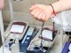 Jersey City Medical Center Pleads for Blood Donations Amid Critical Shortage Close-up of blood donation process showing a donor's arm and blood bags in a clinic.