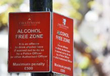 Close-up of red Cheltenham alcohol-free zone sign with maximum penalty warning.