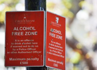Close-up of red Cheltenham alcohol-free zone sign with maximum penalty warning.