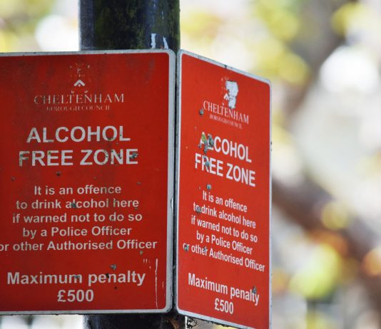 Close-up of red Cheltenham alcohol-free zone sign with maximum penalty warning.
