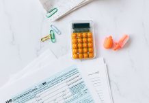 A flat lay image of tax forms, calculator, and office supplies on a desk.