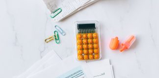 A flat lay image of tax forms, calculator, and office supplies on a desk.