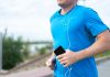 Jersey City’s Vyshyvanka Run Returns to Aid Ukraine Close-up of a man jogging outdoors holding a smartphone wearing earphones.