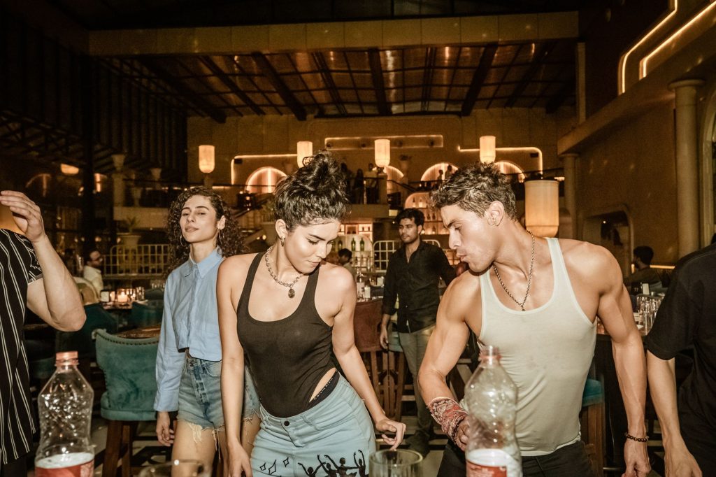 Group of young adults enjoying a lively night out at a trendy Indian bar with friends.