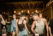 Group of young adults enjoying a lively night out at a trendy Indian bar with friends.