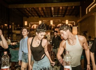 Group of young adults enjoying a lively night out at a trendy Indian bar with friends.
