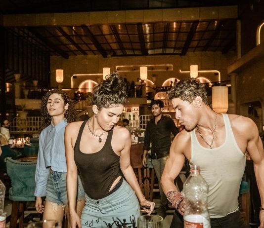 Group of young adults enjoying a lively night out at a trendy Indian bar with friends.