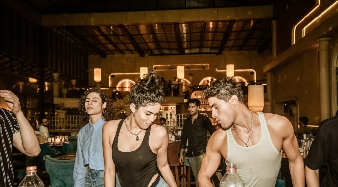 Group of young adults enjoying a lively night out at a trendy Indian bar with friends.