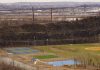 Lo Que Los Locales Aman de Vivir en Elizabeth, NJ en 2026 Aerial view of multi-sport fields in urban park with city skyline and bridge in background.