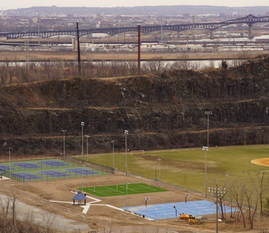 Lo Que Los Locales Aman de Vivir en Elizabeth, NJ en 2026 Aerial view of multi-sport fields in urban park with city skyline and bridge in background.