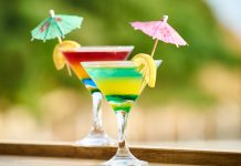 Los mejores lugares en Jersey City para bebidas congeladas este verano Vibrant cocktails with lemon slices and umbrellas, perfect for summer celebrations.