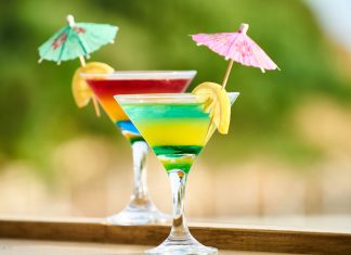 Los mejores lugares en Jersey City para bebidas congeladas este verano Vibrant cocktails with lemon slices and umbrellas, perfect for summer celebrations.