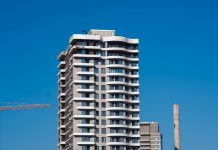 ÚLTIMA HORA: Aprobada torre de 27 pisos en Jersey City A view of a contemporary high-rise building against a clear blue sky in Bornova, İzmir, Türkiye.