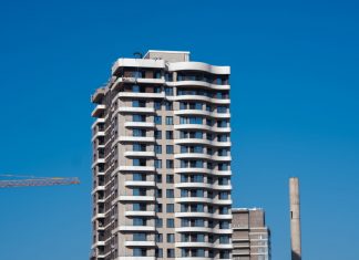 ÚLTIMA HORA: Aprobada torre de 27 pisos en Jersey City A view of a contemporary high-rise building against a clear blue sky in Bornova, İzmir, Türkiye.