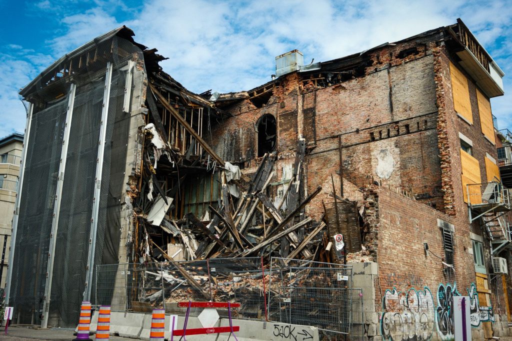 Scene of a partially demolished brick building in Montreal, showcasing urban decay and redevelopment.