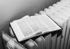 Open Bible on a radiator in black and white, symbolizing warmth and knowledge.