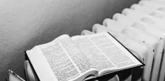 Open Bible on a radiator in black and white, symbolizing warmth and knowledge.