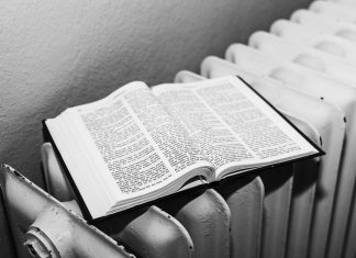 Open Bible on a radiator in black and white, symbolizing warmth and knowledge.