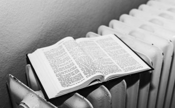 Open Bible on a radiator in black and white, symbolizing warmth and knowledge.