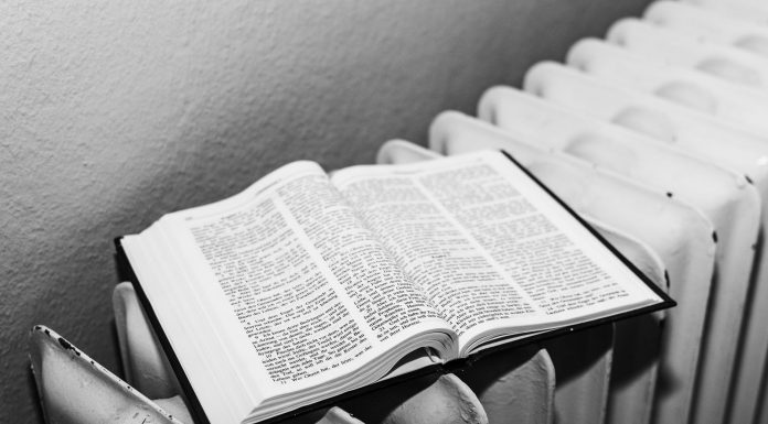 Open Bible on a radiator in black and white, symbolizing warmth and knowledge.