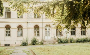 ÚLTIMA HORA: El histórico Griffith Building reabre en Newark A vintage building with arched windows and greenery in a peaceful setting.