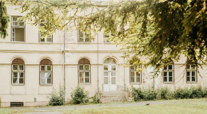ÚLTIMA HORA: El histórico Griffith Building reabre en Newark A vintage building with arched windows and greenery in a peaceful setting.