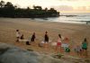 Women practicing yoga on Bondi Beach, Sydney, during a beautiful sunrise.